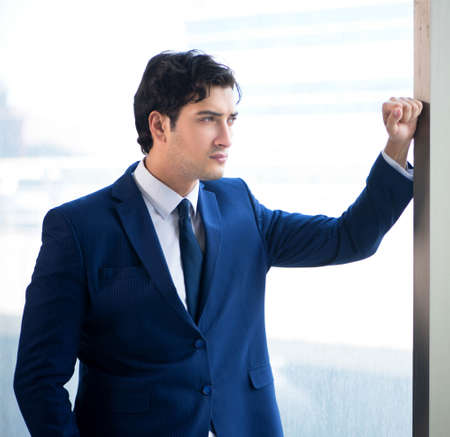 Young handsome businessman standing at the window