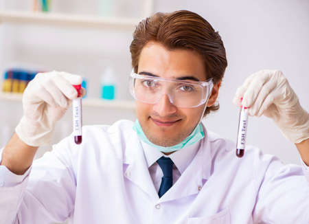 Young handsome lab assistant testing blood samples in hospital