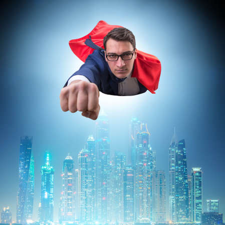Superhero businessman flying over the cityの写真素材