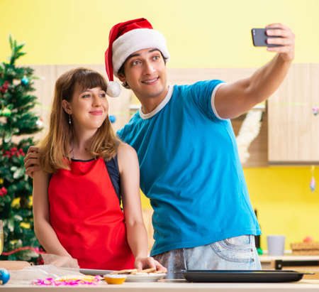 Young couple celebrating Christmas in kitchenの写真素材