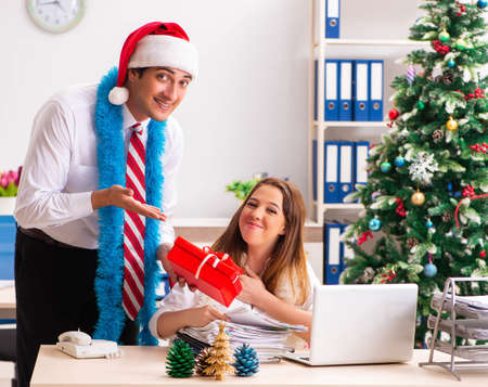 Colleagues exchaing christmas presents in officeの写真素材