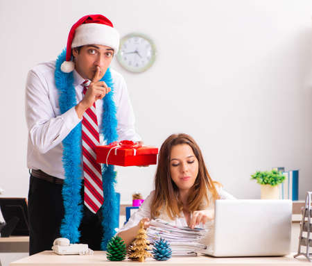 Colleagues exchaing christmas presents in officeの写真素材