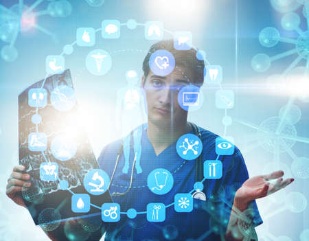 Young doctor looking at x-ray image in mhealth conceptの写真素材