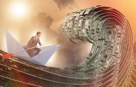 Businessman riding paper boat in dollar seaの写真素材