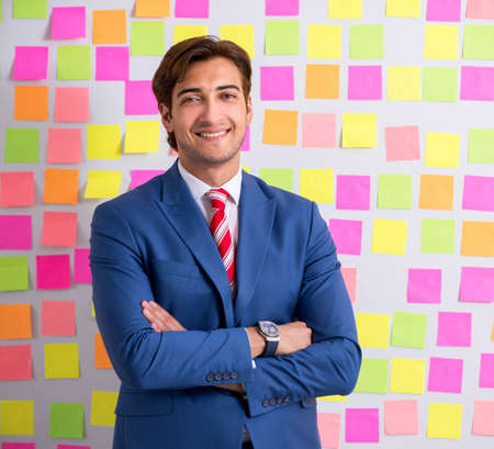 Young handsome man in conflicting priorities conceptの写真素材