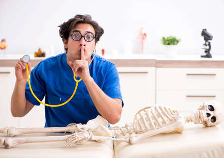 Funny doctor with skeleton in hospitalの写真素材