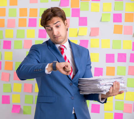 Young handsome man in conflicting priorities conceptの写真素材