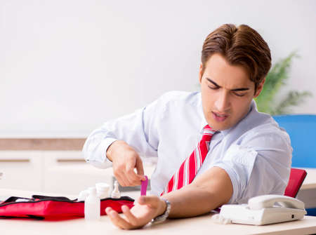 Man with first aid kit in the officeの写真素材