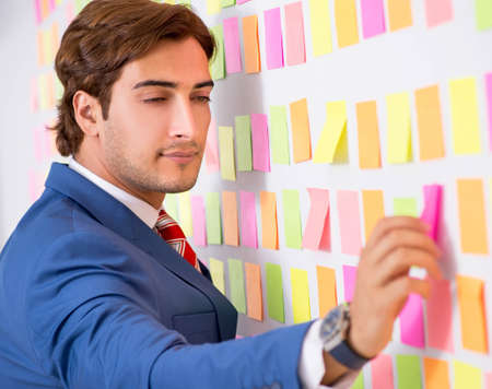 Young handsome man in conflicting priorities conceptの写真素材