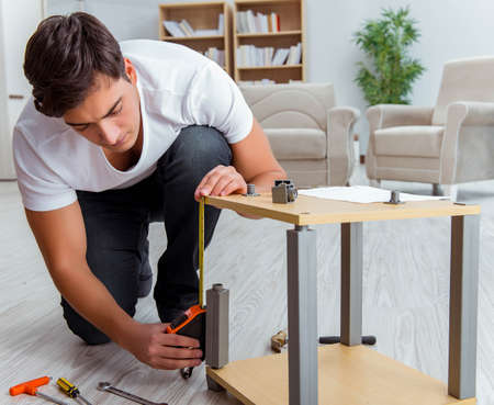 Man assembling furniture at homeの写真素材