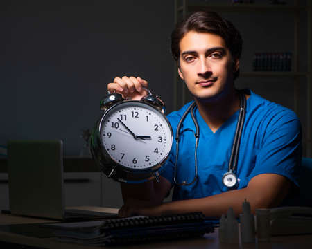 Young handsome doctor working night shift in hospitalの写真素材