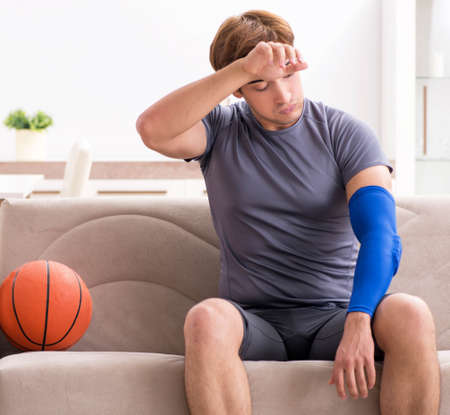 Injured man recovering at home from sports injuryの写真素材