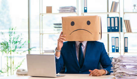 Unhappy man with box instead of his headの写真素材