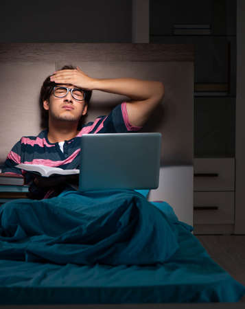 Young student preparing for exams at night at homeの写真素材