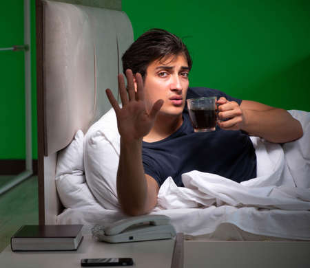 Young handsome man suffering from insomnia at homeの写真素材