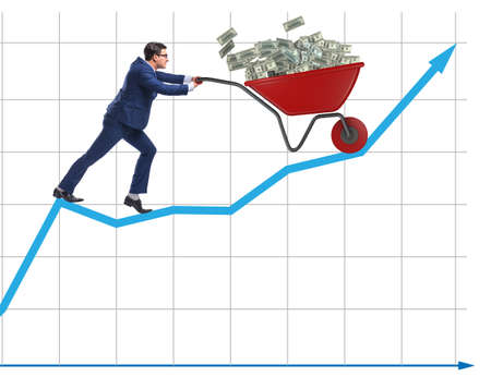 Businessman pushing wheelbarrow full of dollar moneyの写真素材