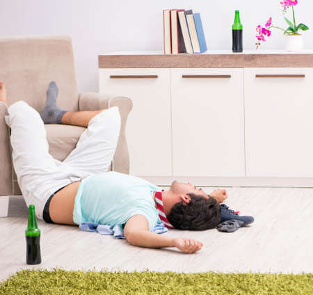 The young drunk handsome man after party at homeの写真素材