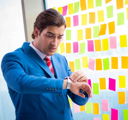 Young handsome employee with many conflicting priorities