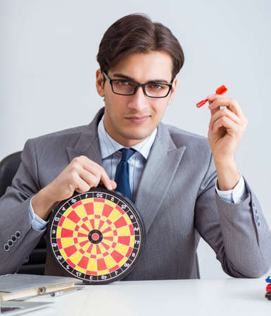 Businessman with dartboard sitting at the officeの写真素材