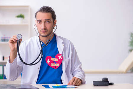 Young male doctor being tired after night shiftの写真素材