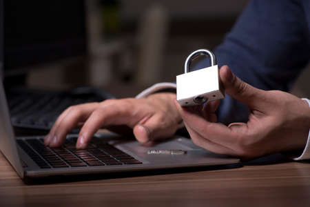 Male hacker hacking security firewall late in the office