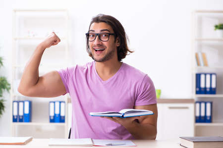 Young male student preparing for exams at classroomの写真素材