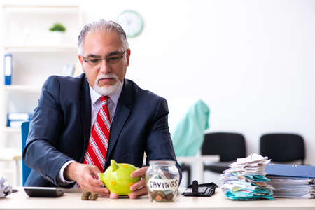 Old male accountant in budget planning conceptの写真素材