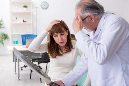 Young woman visiting experienced doctor radiologist