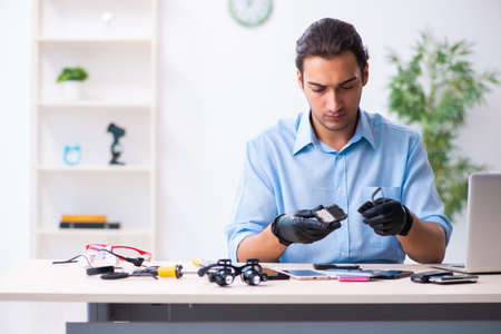 Young male technician repairing mobile phoneの写真素材