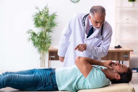 Injured young man visiting old doctor
