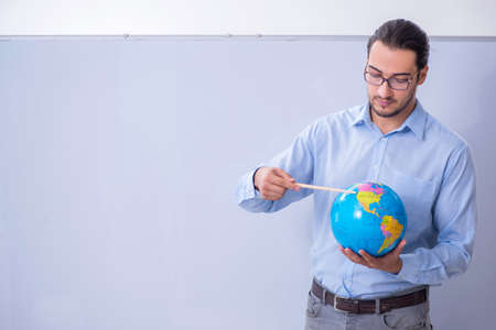 Young male geography teacher in front of whiteboardの写真素材