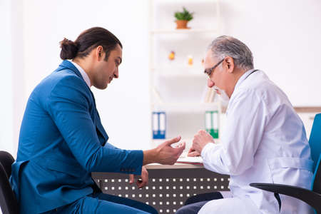 Young businessman meeting with old doctorの写真素材