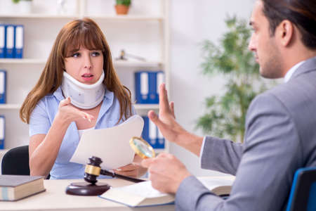 Young injured woman and male lawyer in the courtroomの写真素材