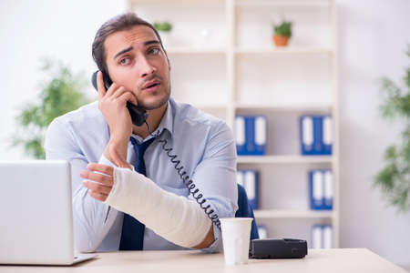 Injured male employee at workplace after accidentの写真素材