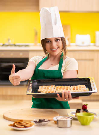 Young cook cooking cakes in the kitchenの写真素材