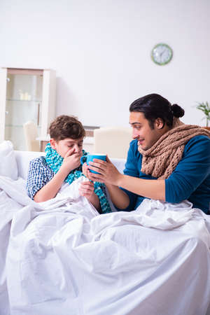 Young father caring for sick sonの写真素材