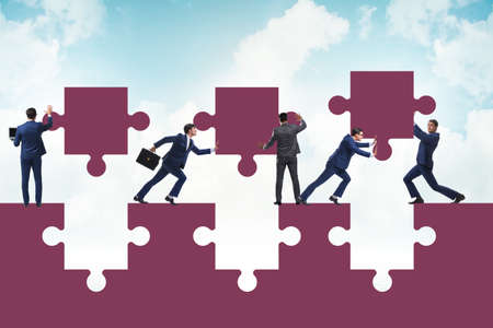 Businessman in the teamwork concept with jigsaw puzzleの写真素材