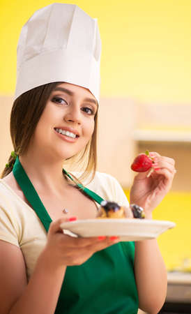 Young cook cooking cakes in the kitchenの写真素材