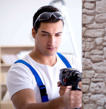 Repairman working with drilling drill perforatorの写真素材