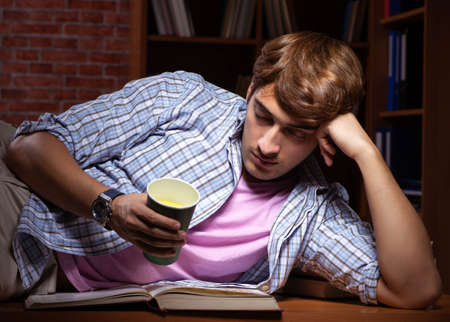 Young handsome student preparing for exams at night