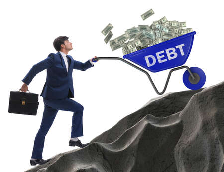 Businessman pushing wheelbarrow uphill in debt loan conceptの写真素材