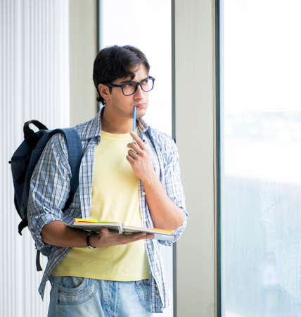 Young handsome student standing at the windowの写真素材