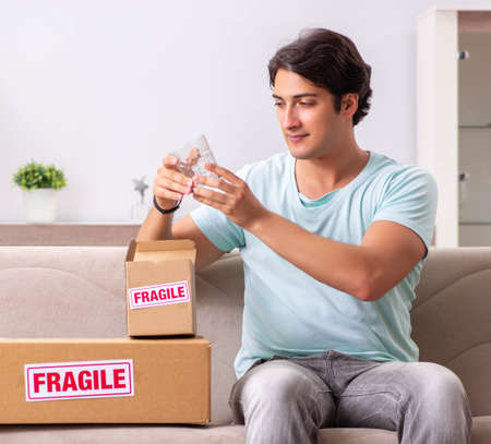 Man opening fragile parcel ordered from internetの写真素材