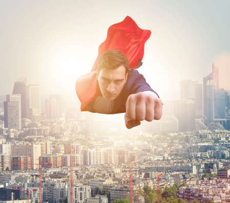 Superhero businessman flying over the city