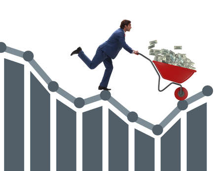 Businessman pushing money wheelbarrow down the chartの写真素材