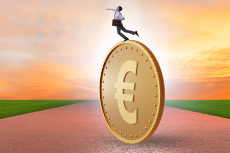 Businessman with giant golden euro coinの写真素材