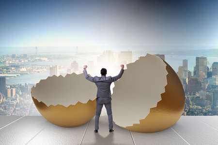 Businessman breaking out of golden eggの写真素材