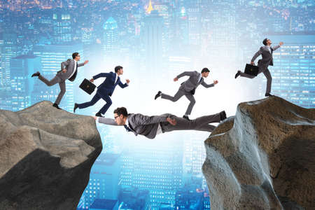 Businessman acting as a bridge in support conceptの写真素材