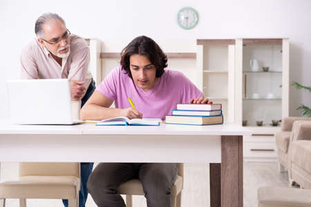 Old father helping his son in exam preparationの写真素材