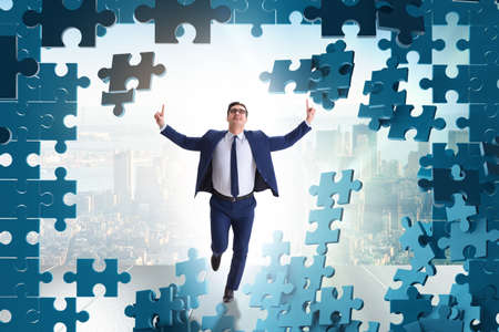 Businessman breaking the wall of jigsaw puzzleの写真素材